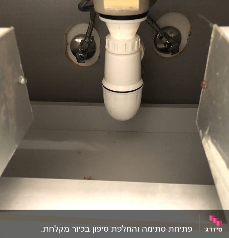 צינור ניקוז לבן מתחת לכיור עם חיבורים